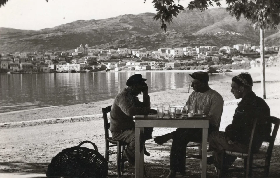 Τρεις άνδρες σε παραλία με θέα.